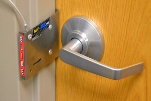 Image of Safe-Latch fast lockdown device in use on out-swing classroom door or office door.