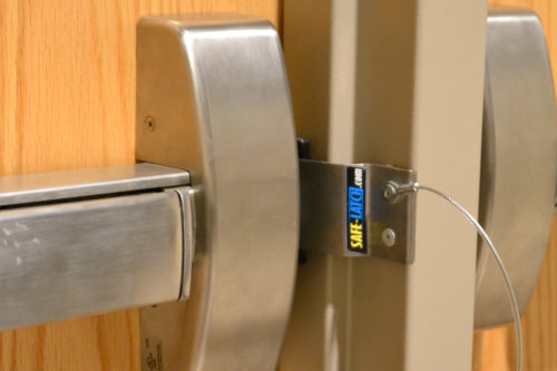 Image of Safe-Latch fast lockdown device in use on an exit door equipped with a panic bar, or in some places called a crash bar.